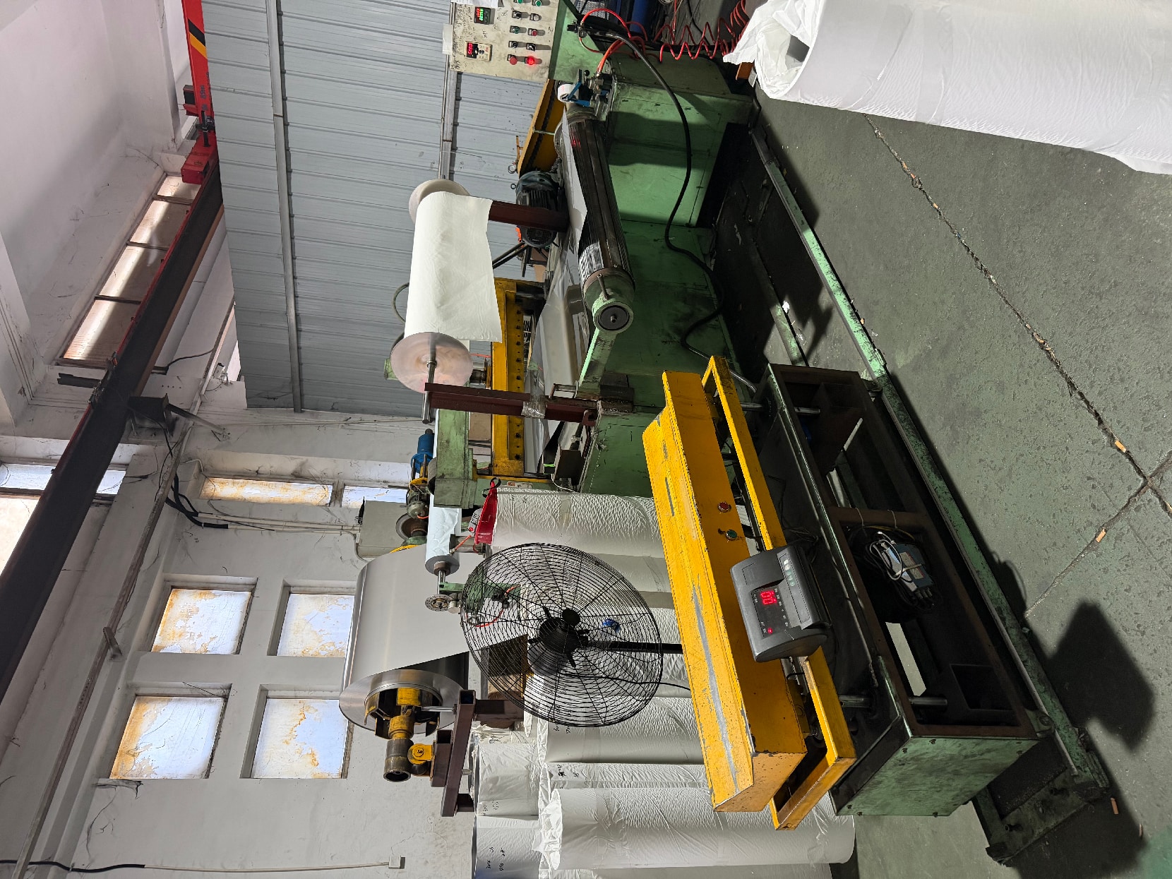 Workshop processing line with an uncoiler, film-wrapped coils and a weighing scale