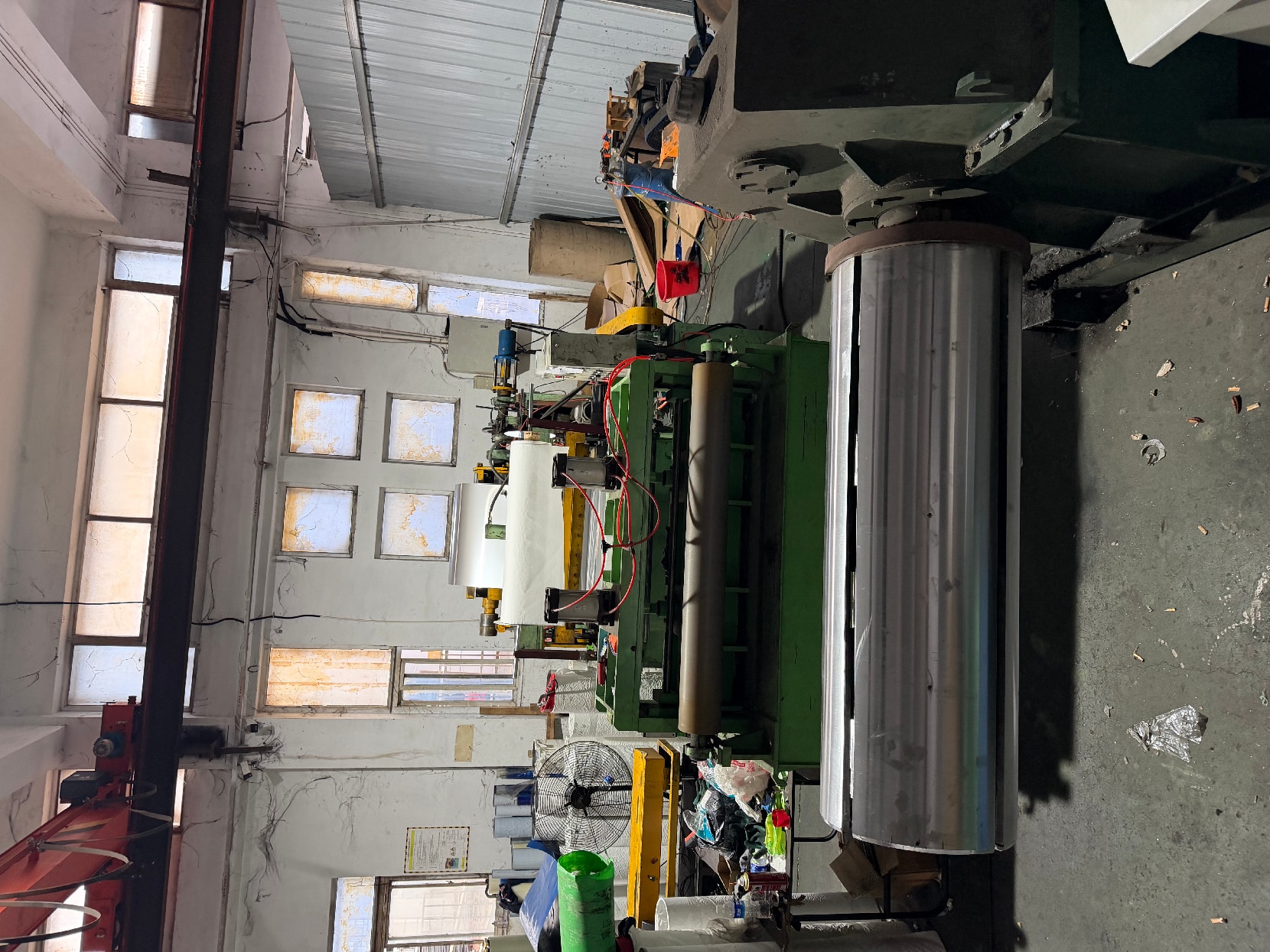 Green processing machine with a large coil mandrel beside film-wrapped stock